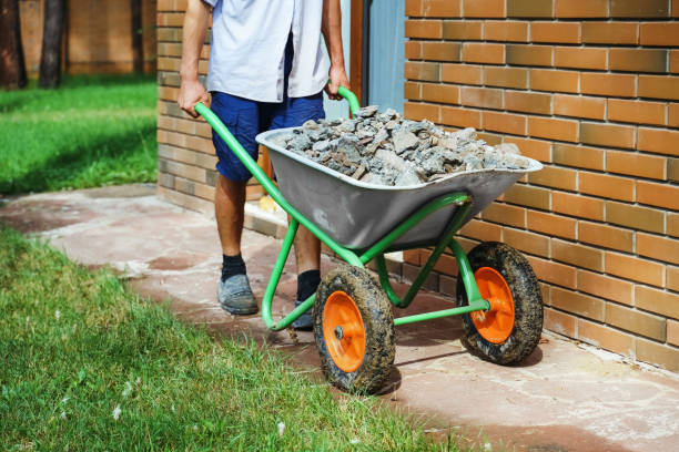 A builder on a trolley transports  paving stones. Paving of pedestrian paths on city streets. Close-up. Unrecognizable person